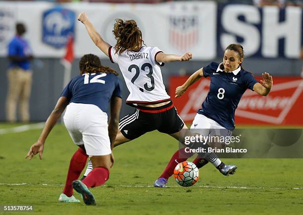 Defender Jessica Houara of France and midfielder Elodie Thomis protect the ball from Germany midfielder Sara Dabritz of Germany during the second...