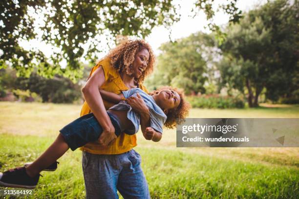 beautiful blonde curly haired mother plays with her adorable bab - hot mom stock pictures, royalty-free photos & images