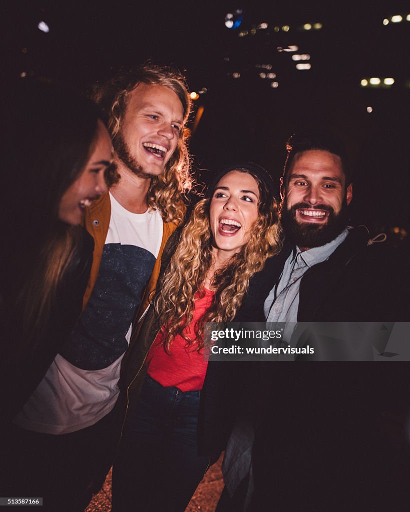 Cheerful teen friends hanging out on evening in city