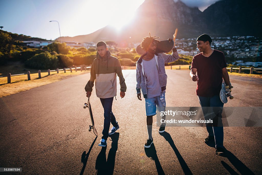 Multi-ethnischen eine Gruppe von Skater zu Fuß entlang der Straße am Meer