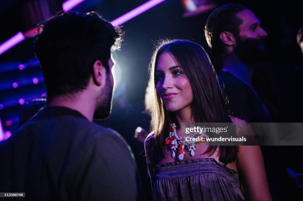 Feliz pareja joven coquetear en un Club nocturno