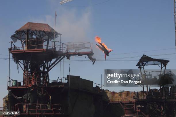 View of a stunt performer on fire and 'falling' from a platform during Universal Studios Hollywood's 'Waterworld: A Live Sea War Spectacular' show,...