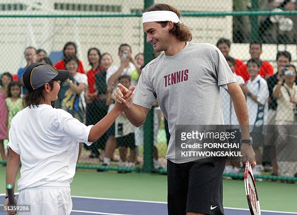 The World number one tennis player, Roger Federer shakes hand with Thai child during the kick-off of a program aimed at giving Thai kids professional...
