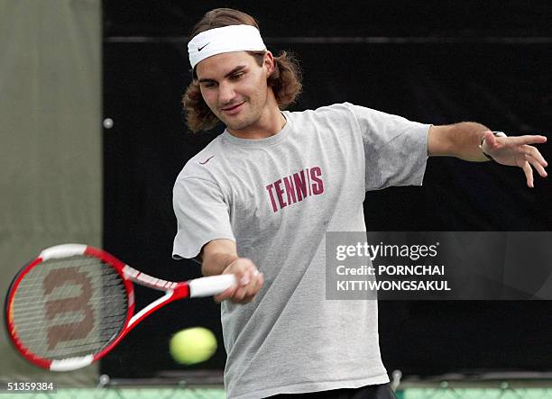 The World number one tennis player, Roger Federer returns a ball during the kick-off of a program aimed at giving Thai kids professional tennis tips,...