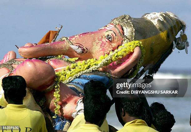 Indian fishermen carry an idol of the elephant-headed Hindu God Lord Ganesh before its immersion in the Bay of Bengal, in Madras 26 September 2004....