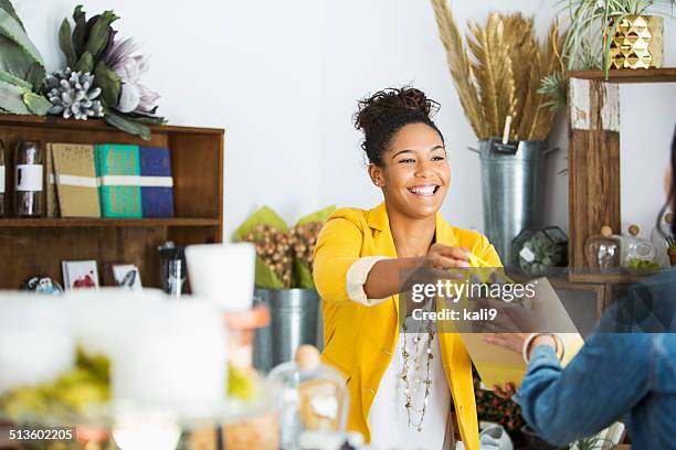 saleswoman helping customer - cliente stockfoto's en -beelden