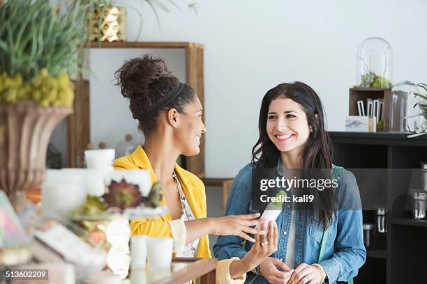 young women in retail shop - gift shop interior stock pictures, royalty-free photos & images