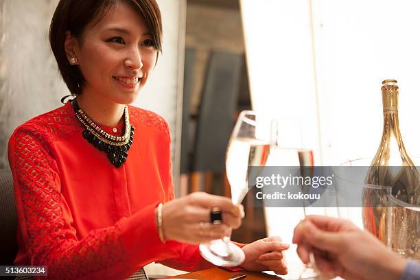 couples drinking champagne in the restaurant - asian couple dining stockfoto's en -beelden