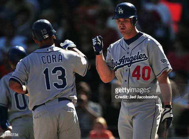 Alex Cora of the Los Angeles Dodgers is congratulated by David Ross after hitting a solo home run against the San Francisco Giants at SBC Park on...