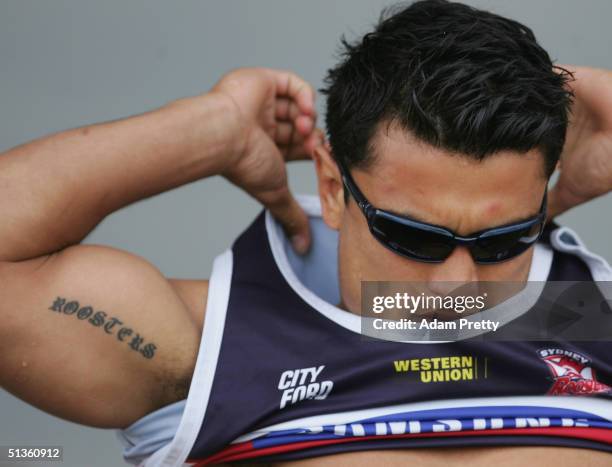 Craig Wing of the Roosters takes off his shirt during training at Bondi Beach September 27, 2004 in Sydney, Australia.