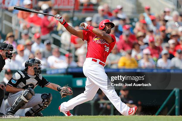 Carlos Peguero of the St Louis Cardinals hits a double scoring a run in the second inning against the Miami Marlins during a spring training game at...