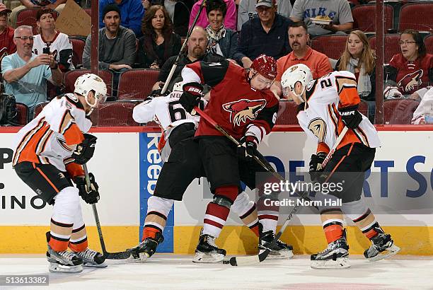 Sergei Plotnikov of the Arizona Coyotes battles for the puck with Stefan Noesen and Mike Santorelli of the Anaheim Ducks as Ryan Garbutt of the Ducks...