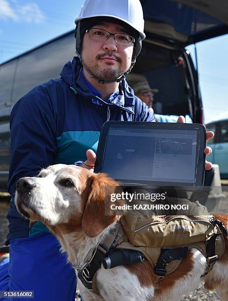 Japan-quake-animal by Natsuko FUKUE This photo taken on February 14, 2016 shows Tohoku University professor Kazunori Ono posing with rescue dog...