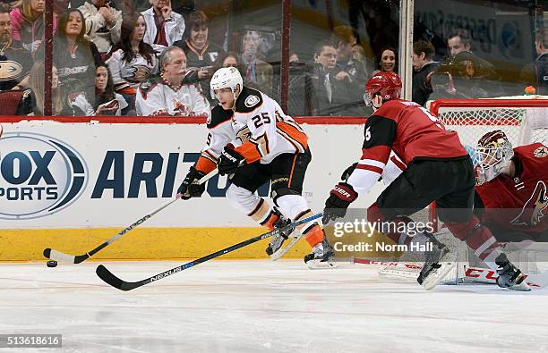 Mike Santorelli of the Anaheim Ducks skates with the puck behind goaltender Niklas Treutle of the Arizona Coyotes as Connor Murphy of the Coyotes...