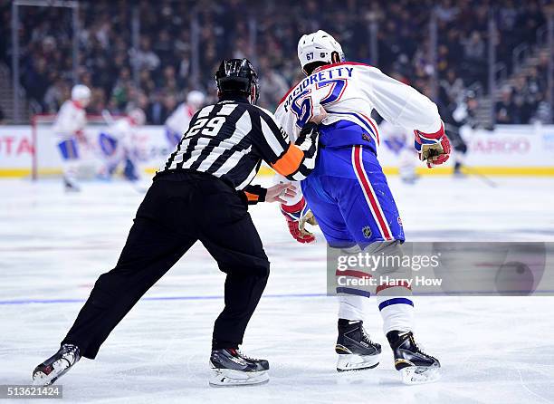 Max Pacioretty of the Montreal Canadiens is pushed by referee Ian Walsh to the bench after losing a blade during the first peroid at Staples Center...