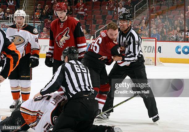 Max Domi of the Arizona Coyotes is restrained by linesman Jay Sharrers after a fight with Ryan Garbutt of the Anaheim Ducks during the third period...