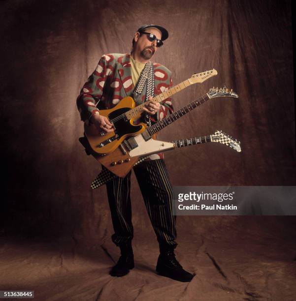 Portrait of American musician Rick Nielsen, of the band Cheap Trick, poses with three of his guitars around his neck, Chicago, Illinois, February 12,...