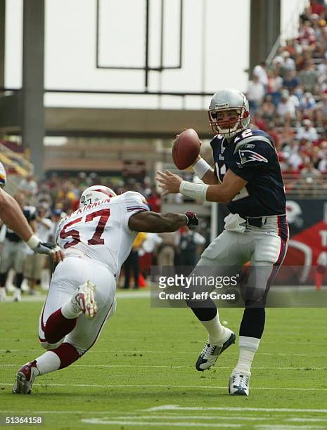 Quarterback Tom Brady of the New England Patriots looks to pass as he is rushed by Ronald McKinnon of the Arizona Cardinals andat Sun Devil Stadium...