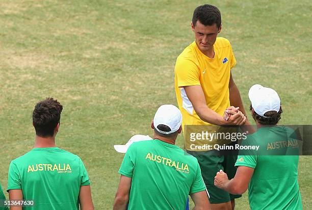 Bernard Tomic of Australia is congratulated by team mates after winning his match against Jack Sock of the United States during the Davis Cup tie...