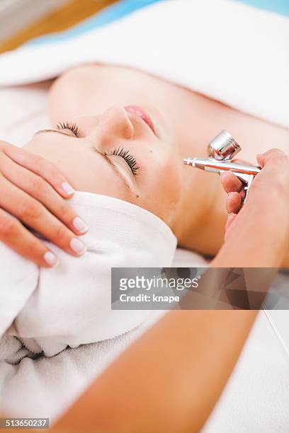 woman getting a facial treatment at the spa - airbrush stock pictures, royalty-free photos & images