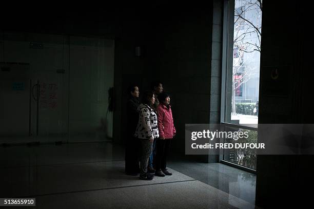 Chinese relatives of the missing MH370 passengers plane stand in Beijing on March 4, 2016. The discovery of a piece of plane debris found in the...