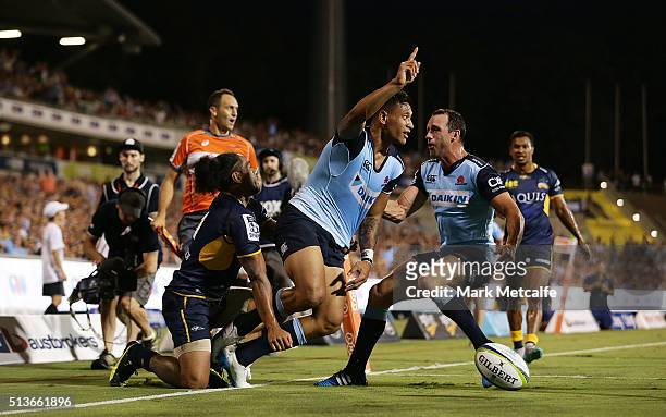 Israel Folau of the Waratahs celebrates scoring a try with team mate Matt Carraro during the round two NRL match between the Brumbies and the...