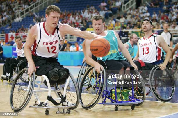 Patrick Anderson of Canada reaches out to grab a loose ball in front of Shaun Norris of Australia during their gold medal wheelchair basketball game...