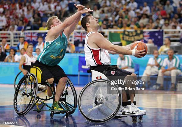 Troy Sachs of Australia gets behind Joey Johnson of Canada too late to make a block during wheelchair basketball on September 28, 2004 during the...