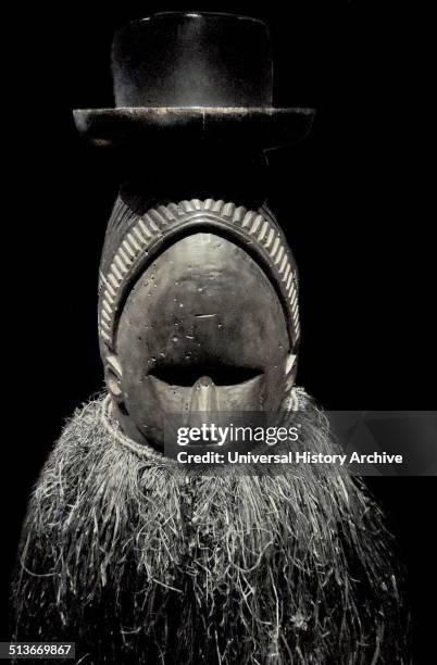 Ndoli jowei in costume of black-dyed raffia. The masker's arms and legs are also covered so that the identity of the wearer is totally concealed....