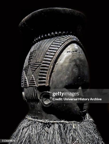 Ndoli jowei in costume of black-dyed raffia. The masker's arms and legs are also covered so that the identity of the wearer is totally concealed....