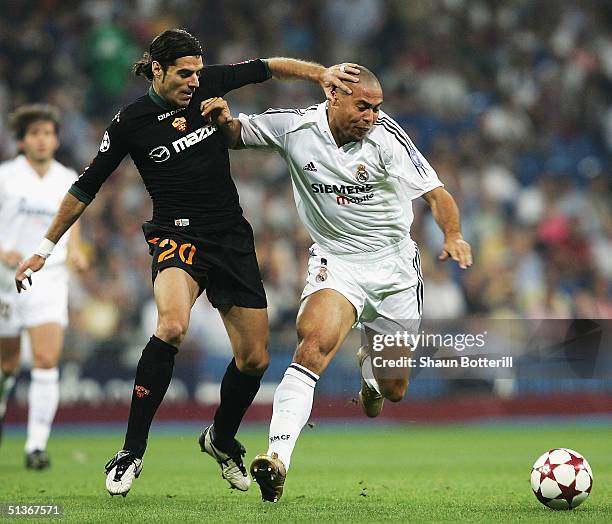 Ronaldo of Real Madrid is challenged by Simone Perrotta of Roma during the UEFA Champions League Group B match between Real Madrid and Roma at the...