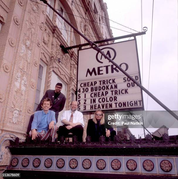 Portrait of American band Cheap Trick posed atop the marquee of the Metro auditorium, Chicago, Illinois, May 1, 1998. Pictured are, from left, Robin...