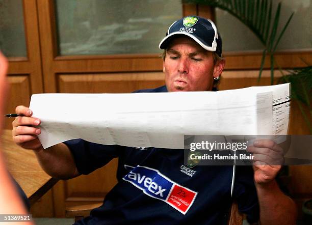 Shane Warne of Australia studies the senate ballot before casting his vote for the upcoming Federal Election at the Australian Consulate on September...