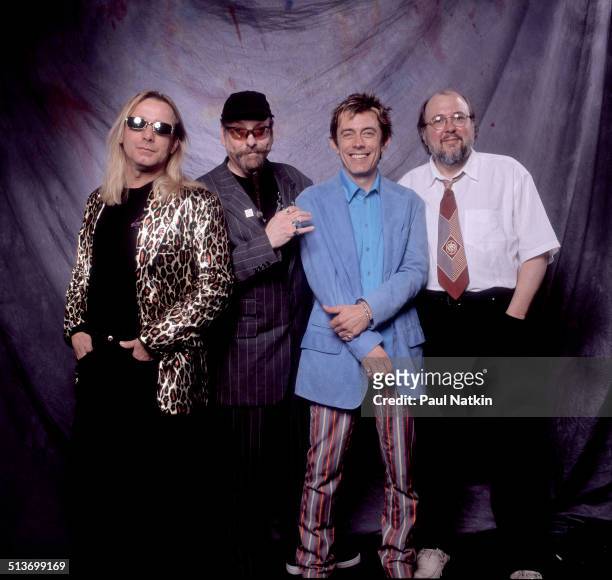 Portrait, from left, Tom Petersson, Rick Nielsen, Robin Zander, and Bun E Carlos of the band Cheap Trick as they pose backstage at the Metro...