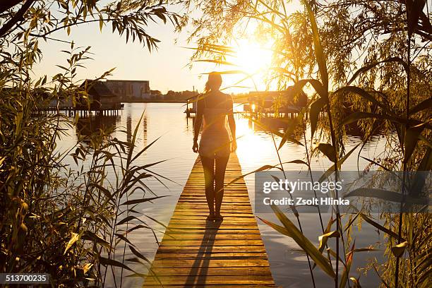 woman on the pier - tata hungary stock pictures, royalty-free photos & images