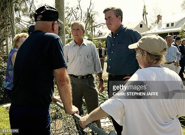 Punta Gorda, United States: US President George W. Bush and his brother Florida Governor Jeb Bush talk to local residents while touring the damage...