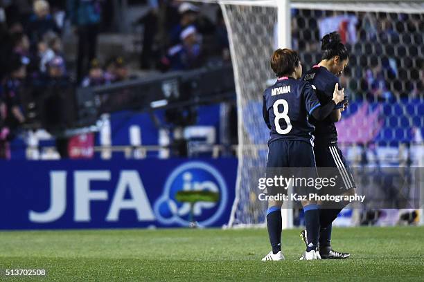 Aya Miyama of Japan consoles her team mate Yuki Ogimi after their 1-2 defeat in the AFC Women's Olympic Final Qualification Round match between Japan...