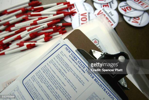 Pens, buttons and registration forms lie on a table during a voter registration drive sponsored by The Partnership for the Homeless September 29,...