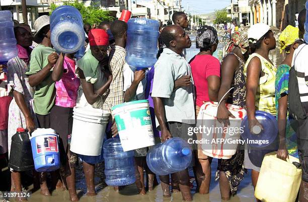 Gonaives residents que for water 29 September 11 days after floods devastated the northern haitian town. Health care workers and rescuers from around...