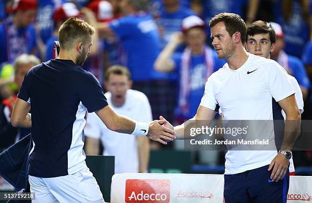 Daniel Evans of Great Britain speaks with Leon Smith the Great Britain team captain during the singles match against Kei Nishikori of Japan on day...