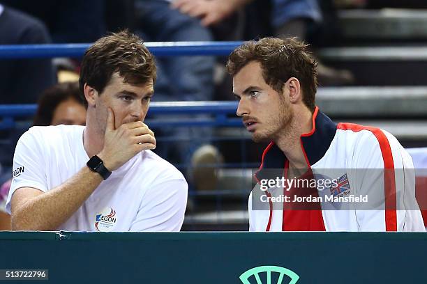 Brothers and teammates Jamie Murray and Andy Murray of Great Britain exchange words during the singles match between Daniel Evans of Great Britain...