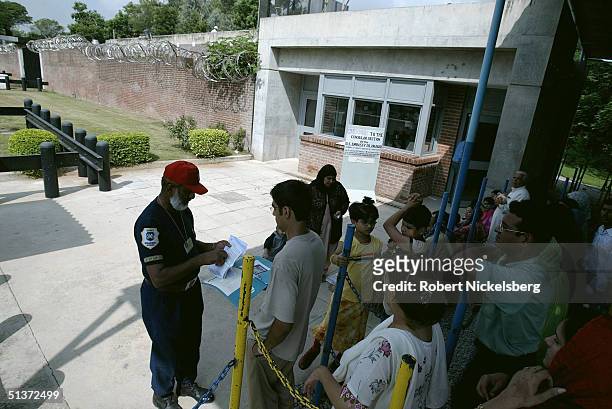 Group of Pakistanis wait in line outside of the US Embassy's Consular section for their visa application appointments on August 13 in Islamabad,...