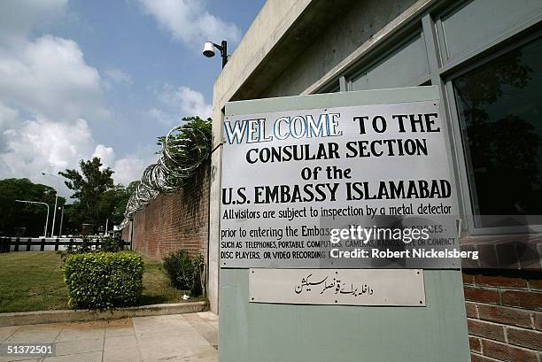 Welcome sign greets a group of Pakistanis as they wait in line outside of the US Embassy's Consular section for their visa application appointments...