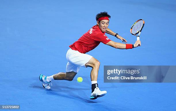 Kei Nishikori of Japan plays a backhand in his singles match against Daniel Evans of Great Britain during day one of the Davis Cup World Group first...