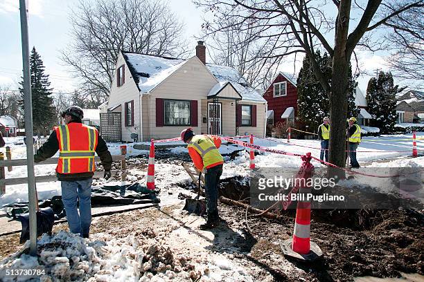 City of Flint, Michigan workers prepare to replace a lead water service line pipe at the site of the first Flint home with high lead levels to have...