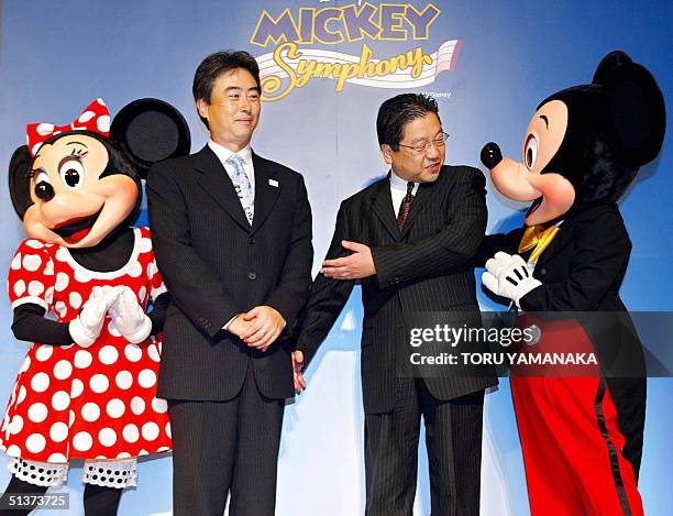 Intel's co-president Kazumasa Yoshida and President of Walt Disney Japan Koji Hoshino share a light moment with Mickey Mouse and Minnie Mouse during...