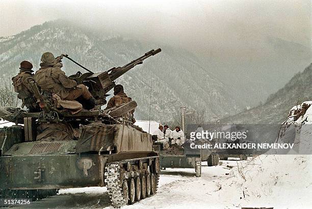 An undated file picture shows Russian soldiers atop an APC taking their position near the village of Shatoy in Chechnya. Military bases are fortified...