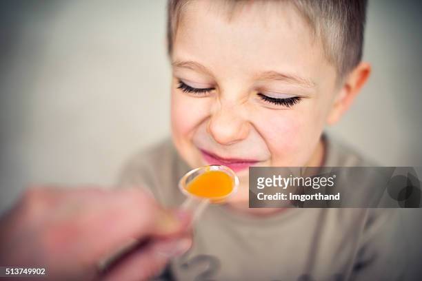 little boy aged 4 taking a medicine - syrup stockfoto's en -beelden