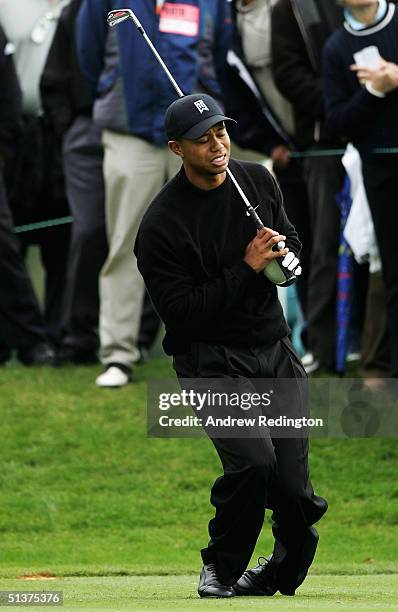 Tiger Woods of the United States winces in pain from a back injury on the sixth tee during the first round of the American Express Championship at...