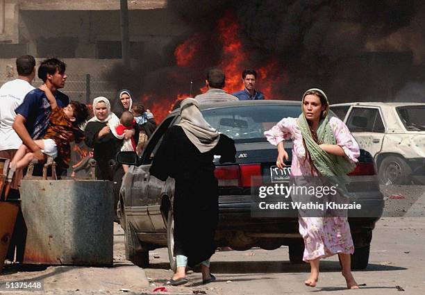 Iraqi citizen's flee the scene after three explosions September 30, 2004 in Baghdad, Iraq. Three seperate explosions near a U.S. Military convoy...